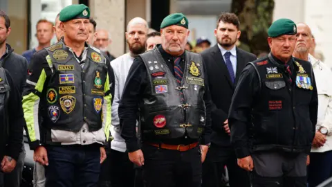 Three men wearing green berets paying tribute