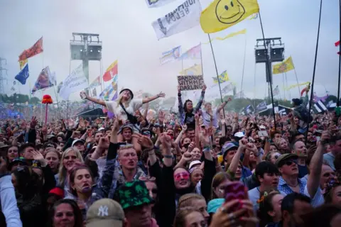 Ben Birchall, PA Crowds at Glastonbury stand and cheer