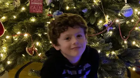 Family photo Dylan Cope in front of a Christmas tree