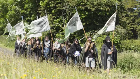 Game of Thrones Tours  Game of thrones fans in costume holding flags on a tour 