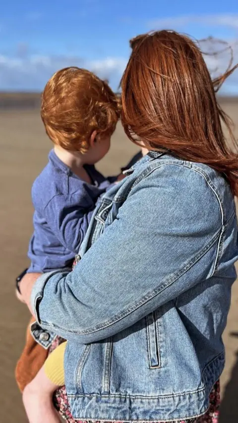 Family picture Woman holds a child on a beach