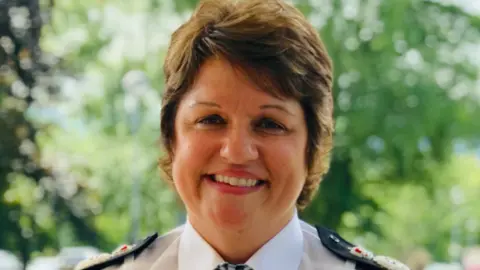 Gwent police A woman with short brown hair, Pam Kelly, smiling at the camera. She is in a police uniform