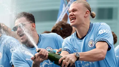 Action Images/Reuters Ederson and Erling Haaland celebrate with champagne