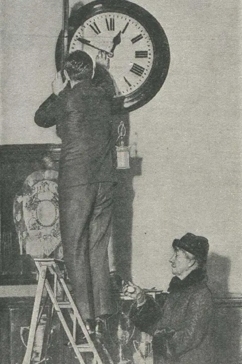 Popular Science Monthly Belville supervising the setting of an office clock