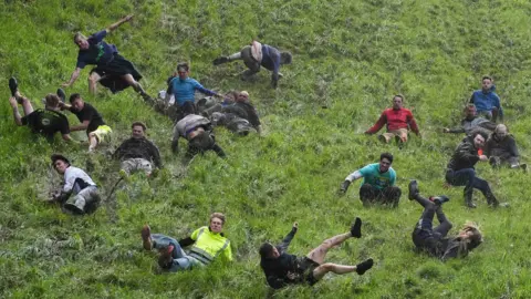 PA Media Men tumbling down a hill