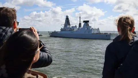 LPhot Belinda Alker HMS Diamond being watched by people in Portsmouth as it sets sail for the Middle East