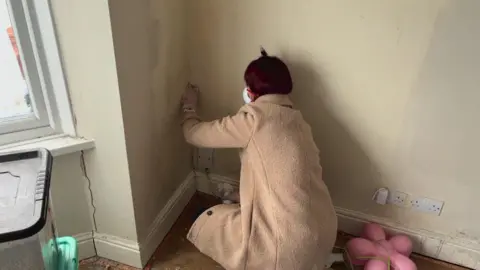 Zoe scrubbing mould off the walls