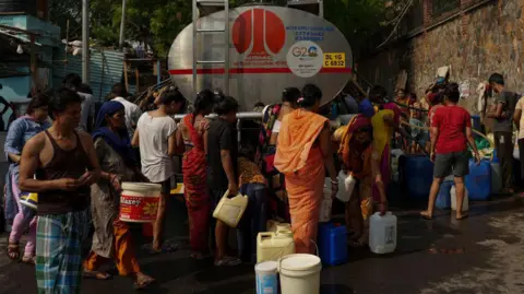 Getty Images NEW DELHI, INDIA - MAY 22: People gather around a municipal tanker to collect water during high temperatures in New Delhi, India, on May 22, 2024. (Photo by Amarjeet Kumar Singh/Anadolu via Getty Images)