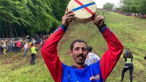 BBC Man holding cheese above his head