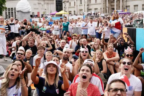 PA Female football fans wearing England shirts watch the football