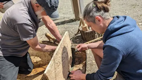 Rockingham Forest Trust A male volunteer on the left and James Dilley on the right fitting a transom board to the end of one of the log boats