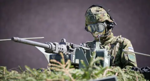 Getty Images An Estonian soldier is seen in a camouflaged armoured personnel carrier in Tapa, Estonia on 20 May 2023.