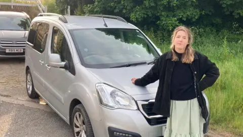 Ellie Rylands Ellie Rylands standing in front of her car 