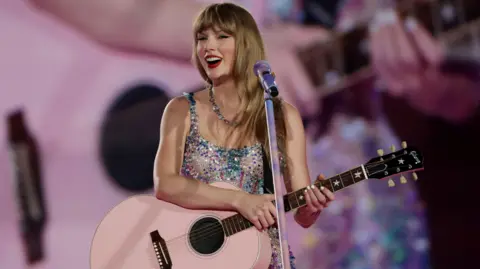 Getty Images Taylor Swift holding a pink guitar
