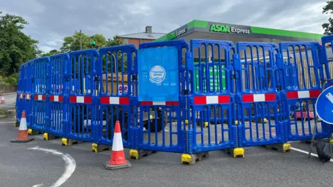 BBC Thames Water works to replace a pipe outside the petrol station where the leak occurred